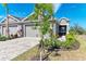Two-story home with gray exterior, paver driveway, and tropical landscaping at 4133 Golden Creek Ter, Parrish, FL 34219