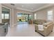 Bright living room with sliding glass doors leading to a patio and neutral colored furniture at 4133 Golden Creek Ter, Parrish, FL 34219