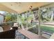 Peaceful screened porch with wicker furniture and view of lush backyard at 4966 Clubview E Ct, Bradenton, FL 34203