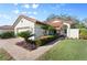 Spanish style home with tile roof, landscaping, and paved driveway at 4966 Clubview E Ct, Bradenton, FL 34203