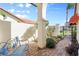 Charming front patio with a blue metal bench and brick pavers at 4966 Clubview E Ct, Bradenton, FL 34203