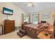 Spacious main bedroom with a queen-size bed, carpet flooring, and access to the patio at 4966 Clubview E Ct, Bradenton, FL 34203
