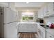 Galley kitchen with white cabinets and appliances at 4459 Beacon Dr, Sarasota, FL 34232