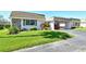Front view of a single story home with attached garage and well-manicured lawn at 2607 Riverbluff Pkwy # V145, Sarasota, FL 34231