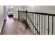 Upstairs hallway with dark wood flooring and iron railing at 228 Crew Ct, Sarasota, FL 34243