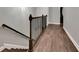 Upstairs hallway with dark wood flooring and metal railing at 228 Crew Ct, Sarasota, FL 34243