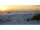 Beautiful beach view at sunset with golden light reflecting on the sand and ocean waves at 2850 Gulf Of Mexico Dr # 2, Longboat Key, FL 34228