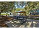 Shaded picnic area with tables and a pavilion surrounded by mature trees near the water at 1111 143Rd Ne St, Bradenton, FL 34212