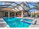 Inviting pool and spa with screened enclosure, outdoor kitchen, and lounge area at 1111 143Rd Ne St, Bradenton, FL 34212