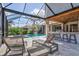 Relaxing covered lanai with an outdoor kitchen, swimming pool and comfortable lounge chairs at 1111 143Rd Ne St, Bradenton, FL 34212