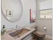 Stylish powder room features unique sink and fixtures, plus a decorative round mirror at 1111 143Rd Ne St, Bradenton, FL 34212