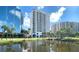 Luxury condominium exterior with a water view, palm trees, and blue skies at 1233 N Gulfstream Ave # 1001, Sarasota, FL 34236
