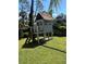 Charming backyard playhouse on stilts, featuring a slide, ladder, and sandbox for outdoor fun at 1594 S Chamberlain Blvd, North Port, FL 34286