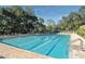 Community swimming pool with lounge chairs and trees at 3121 Longmeadow # 5, Sarasota, FL 34235