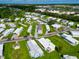 Aerial view of a mobile home community with lush landscaping and paved roads at 6421 Kilohee Ct, North Port, FL 34287