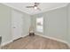 Bright bedroom with wood-look floors, a ceiling fan, and a window with blinds at 6421 Kilohee Ct, North Port, FL 34287