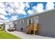 Gray manufactured home with wood steps, golf cart, and shed at 6421 Kilohee Ct, North Port, FL 34287
