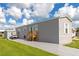 Gray manufactured home with a paved driveway and golf cart at 6421 Kilohee Ct, North Port, FL 34287