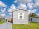 Gray manufactured home with wooden steps and a storage shed at 6421 Kilohee Ct, North Port, FL 34287