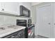 Modern kitchen with black appliances and white cabinets at 6421 Kilohee Ct, North Port, FL 34287