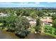 Aerial view of a waterfront community featuring houses and a vacant lot by the lake at 4431 Camino Real, Sarasota, FL 34231