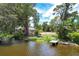Waterfront lot with a small dock and nearby houses at 4431 Camino Real, Sarasota, FL 34231