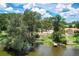 Aerial view of waterfront property with vacant lot and a dock at 4431 Camino Real, Sarasota, FL 34231