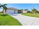 Two-car garage and long driveway leading to a single-story home at 15912 Melport Cir, Port Charlotte, FL 33981