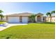 Single-story home with two-car garage and lush lawn at 15912 Melport Cir, Port Charlotte, FL 33981