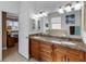 Double vanity bathroom with granite countertops and large mirror at 15912 Melport Cir, Port Charlotte, FL 33981
