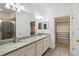 Elegant bathroom with double vanity, granite countertop, and walk-in closet at 11722 Bluebird Pl, Bradenton, FL 34211