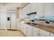 White kitchen cabinets, granite countertops, and stainless steel appliances at 393 N Point Rd # 801, Osprey, FL 34229