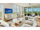 Light-filled living room featuring hardwood floors, comfy seating, and a large TV at 393 N Point Rd # 801, Osprey, FL 34229