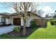 One-car garage with wooden door and landscaping at 610 Pine Ranch East Rd, Osprey, FL 34229