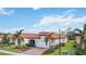 One-story home with a terracotta tile roof, white garage door, and landscaped front yard at 10141 Fiddlewood Dr, Venice, FL 34293