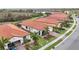 Aerial view of a community with several houses featuring red tile roofs and lush landscaping at 10141 Fiddlewood Dr, Venice, FL 34293