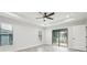 Main bedroom featuring ceiling fan, sliding door to patio, and tile floors at 11213 Gulfstream Blvd, Port Charlotte, FL 33981