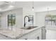 Kitchen island with granite countertop and farmhouse style sink at 11213 Gulfstream Blvd, Port Charlotte, FL 33981