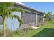Side view of the house, highlighting the screened porch and landscaping at 11213 Gulfstream Blvd, Port Charlotte, FL 33981