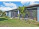 View of the home's exterior showcasing the screened porch and landscaping at 11213 Gulfstream Blvd, Port Charlotte, FL 33981