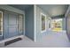 Inviting front porch with blue exterior door and view of the screened porch at 11213 Gulfstream Blvd, Port Charlotte, FL 33981