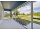 Spacious screened porch overlooking a grassy yard with a view of the street at 11213 Gulfstream Blvd, Port Charlotte, FL 33981