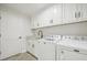 Laundry room with white cabinets, granite countertops, and modern appliances at 11213 Gulfstream Blvd, Port Charlotte, FL 33981