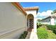Side view of the house showcasing the arched entryway and neat landscaping at 3924 Alamanda Dr, Sarasota, FL 34238