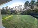 Backyard view featuring a grassy area and tree-lined backdrop at 5240 11Th E St, Bradenton, FL 34203