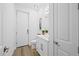 This half-bath features modern fixtures, a clean white aesthetic, wood-look floors, and a stylish vanity at 577 Venice Ln, Sarasota, FL 34242