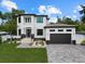 Elegant two-story house with well-maintained lawn, modern design, and a large paved driveway at 577 Venice Ln, Sarasota, FL 34242