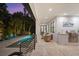Outdoor living space with pool, stainless grill, covered seating, and travertine pavers at 577 Venice Ln, Sarasota, FL 34242