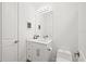 White powder room with single vanity, mirror, toilet and modern fixtures at 577 Venice Ln, Sarasota, FL 34242