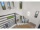 Modern staircase with iron railings, wood treads, and large windows providing ample natural light at 577 Venice Ln, Sarasota, FL 34242